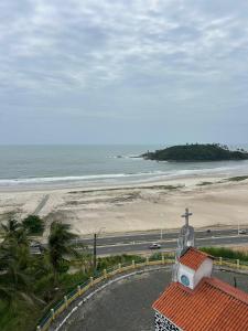 a building with a cross on top of it next to a beach at Apartamento Outeiro in Ilhéus