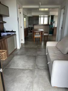 a living room with a couch and a table at Apartamento Outeiro in Ilhéus +2 photos