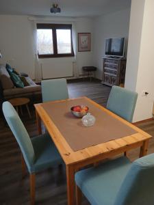 a dining room table with a bowl of fruit on it at Kod bake in Oštarije