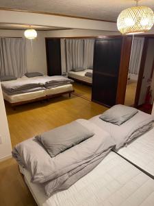 a bedroom with two beds and a chandelier at Huis Tashiro in Yuzawa