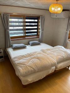 a large bed in a room with a window at Huis Tashiro in Yuzawa