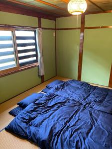 a large blue bed in a room with a window at Huis Tashiro in Yuzawa