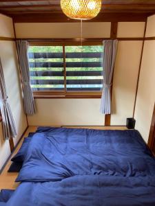a bedroom with a blue bed in front of a window at Huis Tashiro in Yuzawa