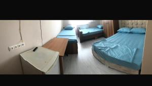 een kleine kamer met 2 bedden en een bureau bij Grand Aral Otel 