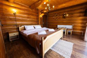 una camera con un letto in una baita di tronchi di Mocearu Retreat 