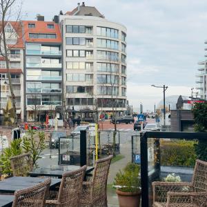 a balcony with a table and chairs and a building at Hotel Villa Verdi in Knokke-Heist +15 photos
