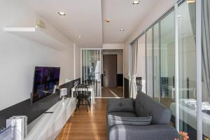 uma sala de estar com um sofá e uma mesa em The1 Ratchaphruek I วิวเมืองนนทบุรี em Ban Nong Bua