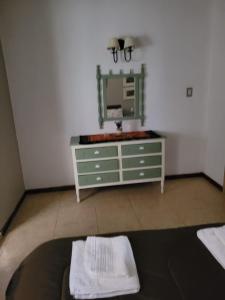 ein Badezimmer mit grüner Kommode und Spiegel in der Unterkunft Departamentos serranos - Menta y Peperina in La Falda