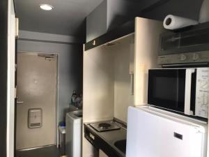 a small kitchen with a microwave and a refrigerator at LEGALCOURT - Vacation STAY 14717 in Akiruno