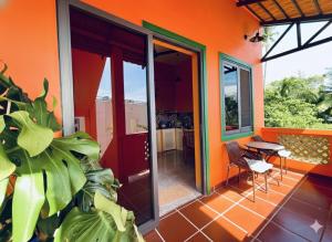 Casa arancione dotata di balcone con tavolo e sedie. di Orange Villa Muine a Mui Ne Altre 17 foto