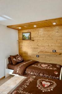 twee bedden in een kamer met houten wanden bij Maso Patrizia - Rifugio caldo tra le vette in Pieve Tesino