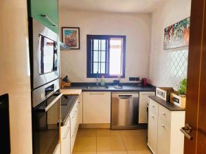 a kitchen with a sink and a stove top oven at Villa Vista with heated pool & Jacuzzi in Playa Blanca