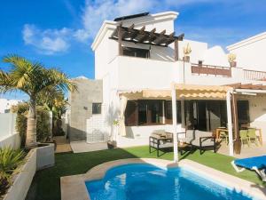 a villa with a swimming pool in front of a house at Villa Vista with heated pool & Jacuzzi in Playa Blanca