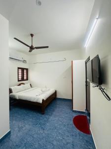 ein Schlafzimmer mit Bett und Flachbildfernseher in der Unterkunft AK Residency Auroville in Kuilapayam