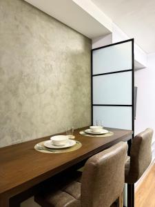 a dining room with a wooden table and chairs at The UrbanNest - 1BR Condo in Marina Spatial, Dumaguete with free fast WiFi and Pool in Piapi