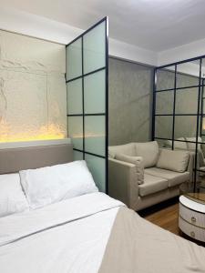 una camera da letto con un letto e un divano di The UrbanNest - 1BR mountain view condo at Marina Spatial a Piapi Altre 6 foto