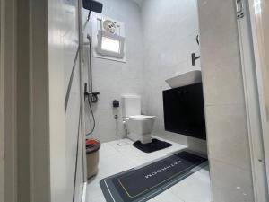 a bathroom with a toilet and a tv in it at Younis chalet in Dahab +13 photos