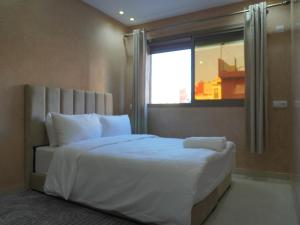 ein Schlafzimmer mit einem großen weißen Bett mit einem Fenster in der Unterkunft Shams House surf in Imsouane