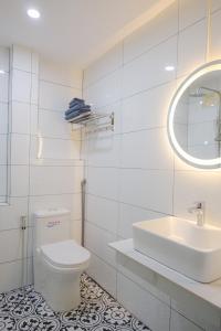 ein weißes Badezimmer mit Toilette und Waschbecken in der Unterkunft De Rivé Homestay Cần Thơ in Cần Thơ + 16 Fotos