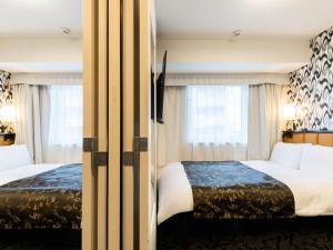 Postel nebo postele na pokoji v ubytování APA Hotel Shin Osaka Minamikata Ekimae