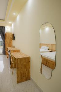 ein Schlafzimmer mit einem Spiegel, einem Bett und einem Schreibtisch in der Unterkunft De Rivé Homestay Cần Thơ in Cần Thơ