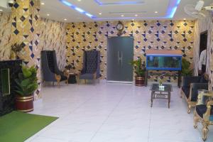 a lobby with chairs and a fish tank on the wall at Hotel Shanze Palace in Lahore
