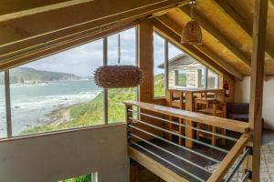 a room with a balcony with a view of the ocean at Cabaña Mirador de ballenas,Chiloé in Ancud