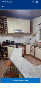 eine Küche mit weißen Schränken und einer Arbeitsplatte in der Unterkunft morada da felicidade in São Gabriel