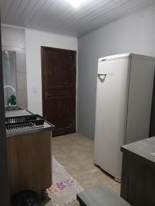 una cucina con frigorifero e porta di Kitnet e casa mobiliada a Penha