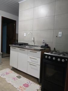 una cucina con lavello e fornello di Kitnet e casa mobiliada a Penha