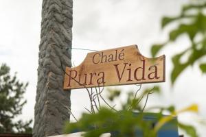 een bord met de tekst 'chalky rino vida' bevestigd aan een boom bij Mirante - Chalé Pura vida in Uruçuca