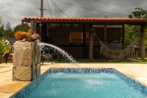 een zwembad met een fontein in een tuin bij Mirante - Chalé Pura vida in Uruçuca