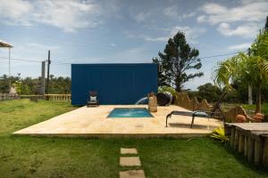 een zwembad in een tuin met een blauwe muur bij Mirante - Chalé Pura vida in Uruçuca