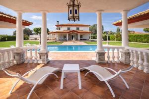 un patio con sedie e tavolo di fronte a una casa di Casa Rural Los Gaspares a La Carlota