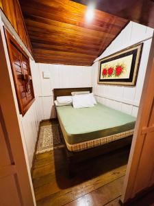 ein kleines Zimmer mit einem Bett in einem Haus in der Unterkunft Sítio Feltz in Canelinha