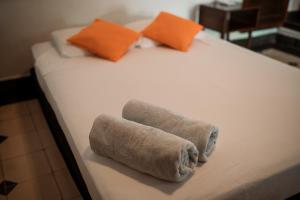 a bed with two rolled up towels on it at Encuentros in Granada