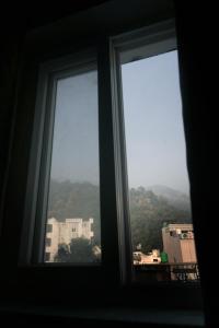 una finestra con vista su un edificio e una montagna di Hotel 7 Chakra In a Rishikesh