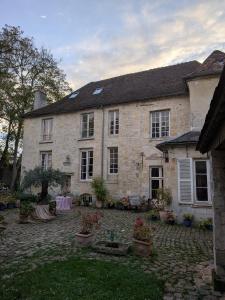 een groot bakstenen huis met een binnenplaats ervoor bij Irène in Senlis