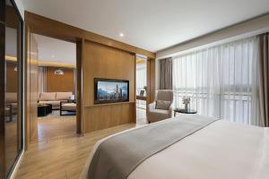 a bedroom with a bed and a living room at Hongdu Hotel in Shenzhen
