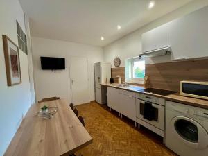 een keuken met een houten tafel en een aanrechtblad bij T4 L'essentiel Gare d'Oullins - 3 chambres - 4 lits - 15 min de Lyon in Oullins +20 foto's