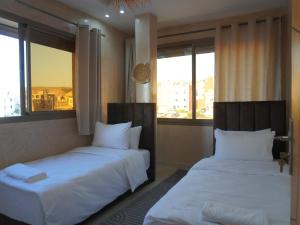 due letti in una stanza con due finestre di Shams House a Imsouane
