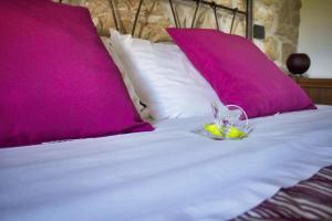 a toy rabbit sitting on top of a bed with pink pillows at Masseria Monte Pizzi in Carovilli