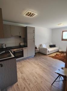 een woonkamer met een witte bank en een keuken bij Chalet l'O - Charm and Modernity in Leytron +34 foto's