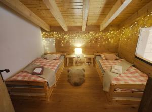 een kamer met twee bedden in een houten huis bij Chalet l'O - Charm and Modernity in Leytron