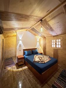 una camera da letto con letto blu in una camera in legno di Relax Beach Camp a Nuweiba‘ el Muzeinah