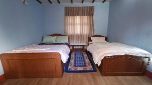 two beds sitting next to each other in a room at BJ's Farmhouse in Nagarkot