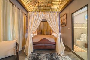 una camera con letto a baldacchino e un bagno di PP Place cnx 2 a Chiang Mai