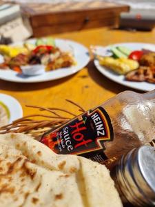 un tavolo con una bottiglia di pane e piatti di cibo di Relax Beach Camp a Nuweiba‘ el Muzeinah