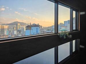 een raam met uitzicht op een stad bij Staykor Busan in Pusan