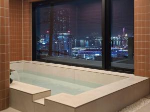 een bad met uitzicht op de stad in de nacht bij Staykor Busan in Pusan +34 foto's